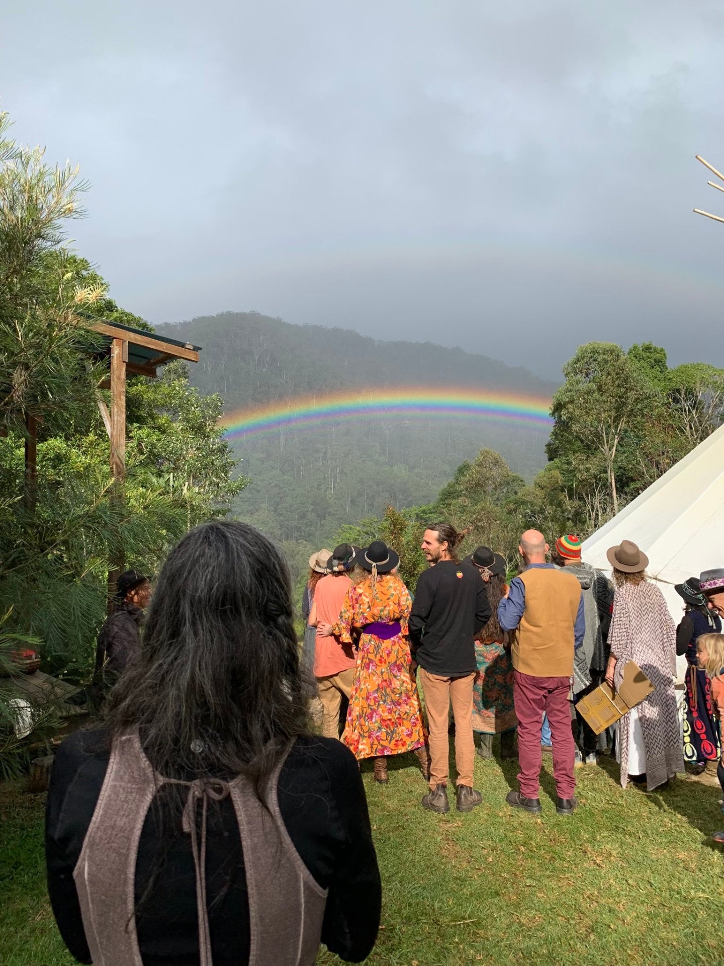 Community gathered beneath a rainbow