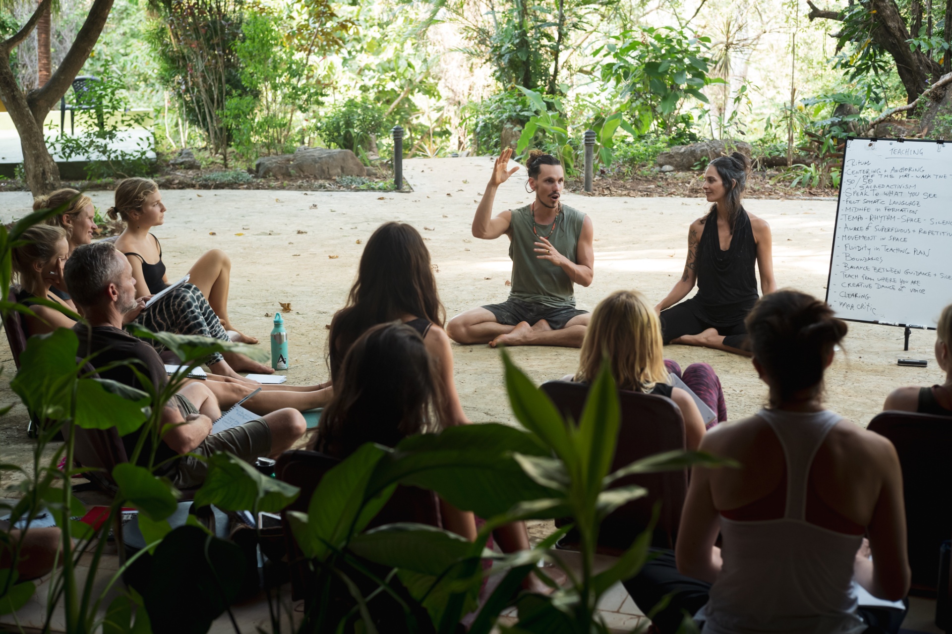 Velan teaching an outdoor circle alongside Adya