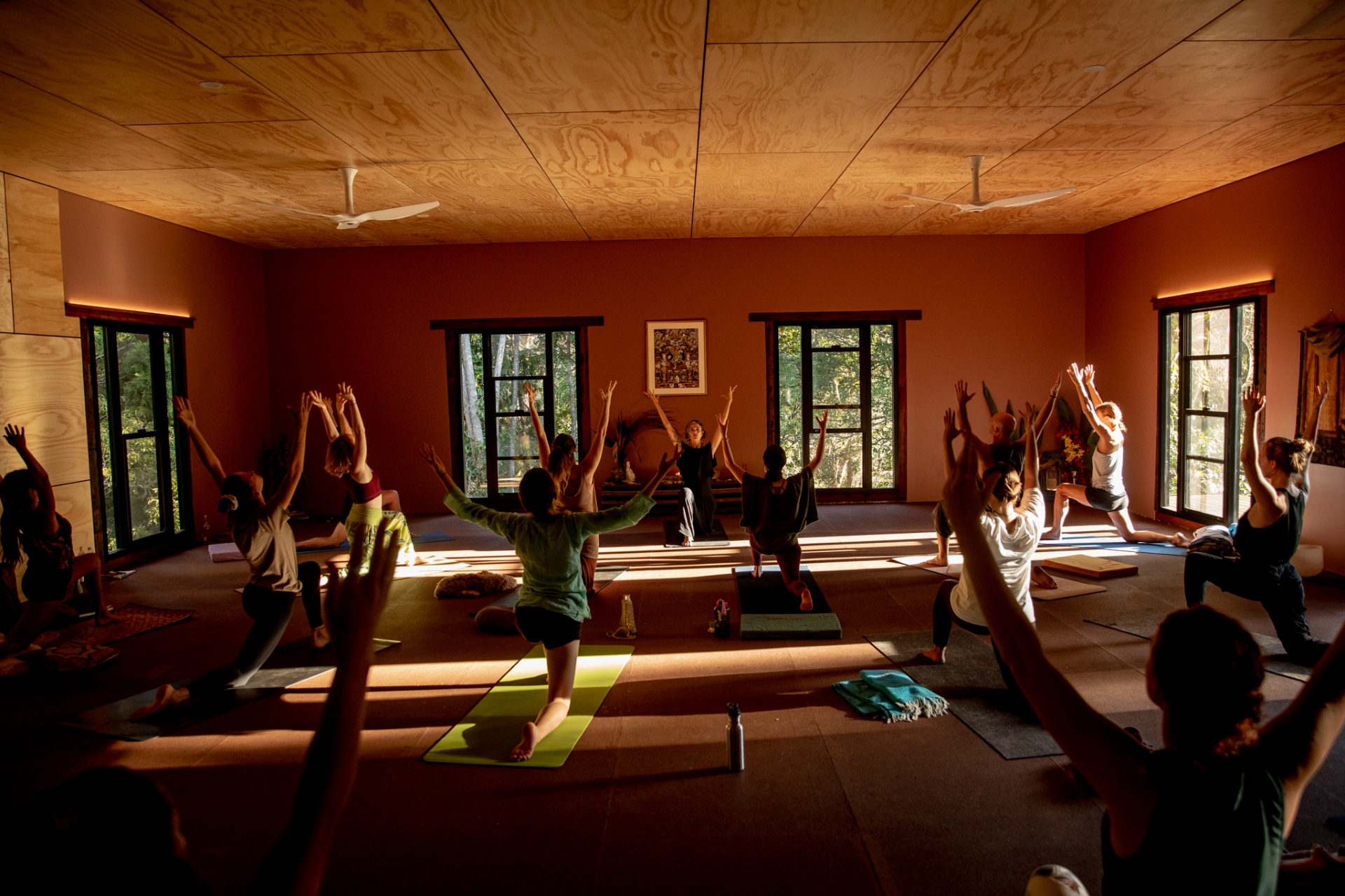 Adya guiding a yoga class in the timber studio